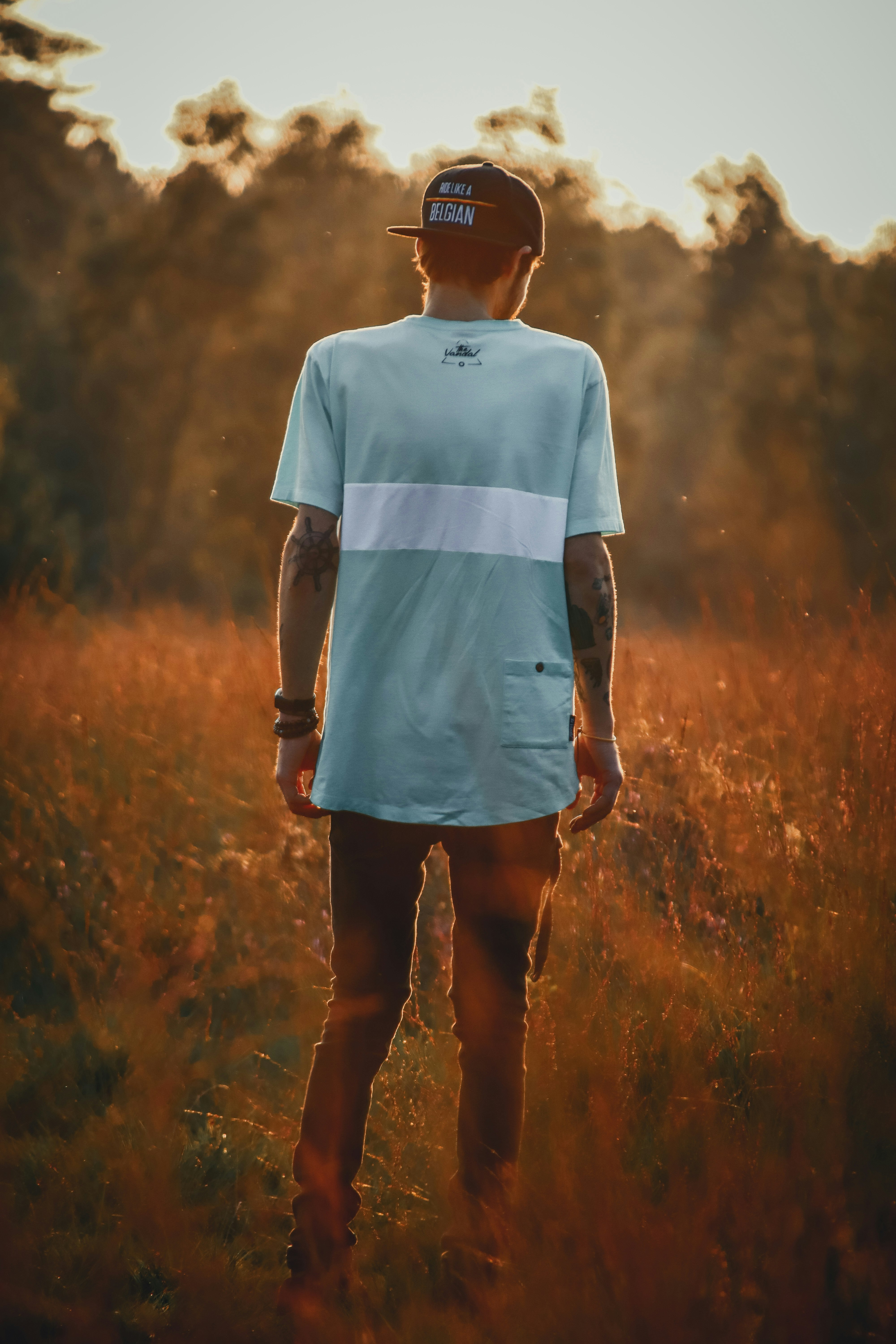 woman in white crew neck t-shirt standing on brown grass field during daytime